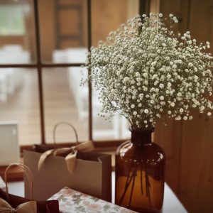 Rental amber glass jug vase with baby's breath in Hickory, NC.